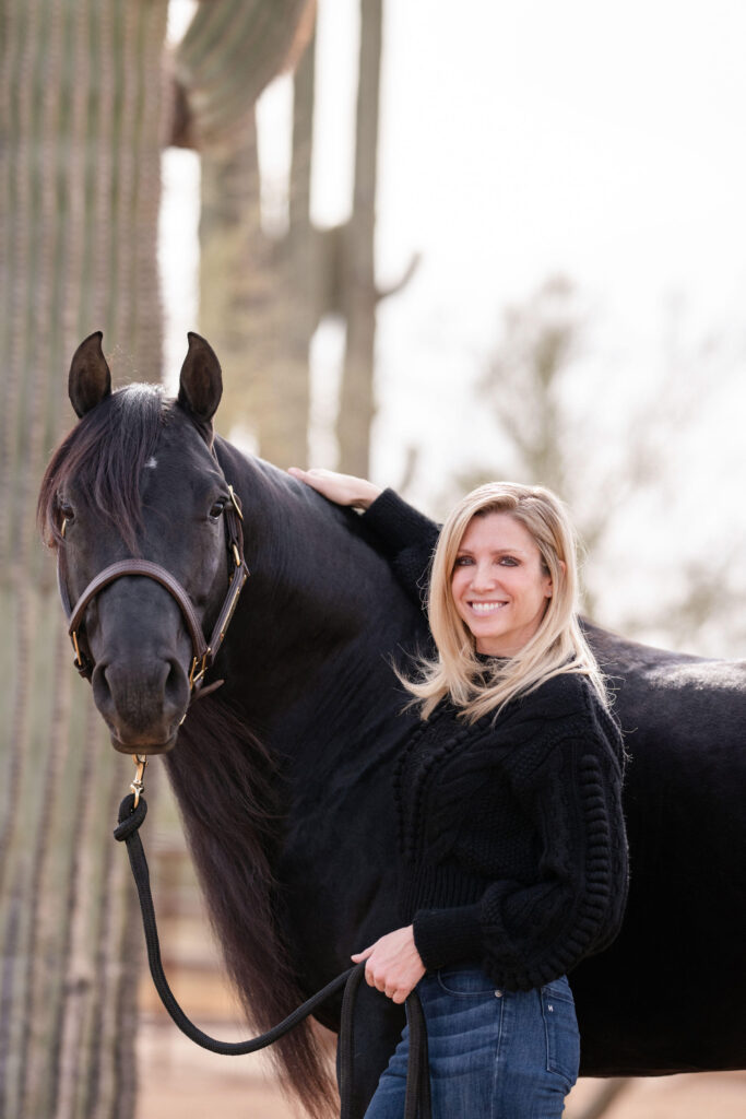 Woman smiling with her black horse.