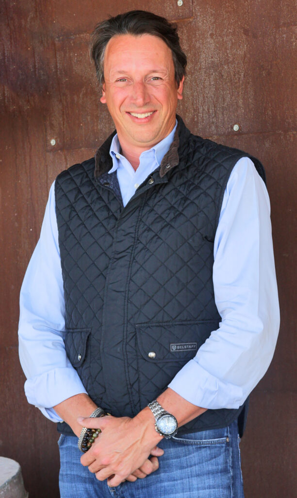 Man in blue shirt and quilted vest.